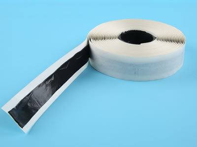 Double sided butyl tape with unfolded part is put flatwise on the blue background.